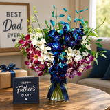 Colourful orchid Father’s Day floral arrangement in glass vase with elegant setup